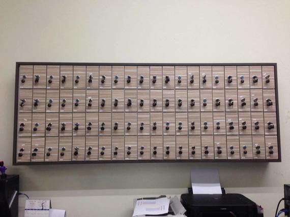 Key storage board with rows of labeled key compartments, black keys, and a printer below.