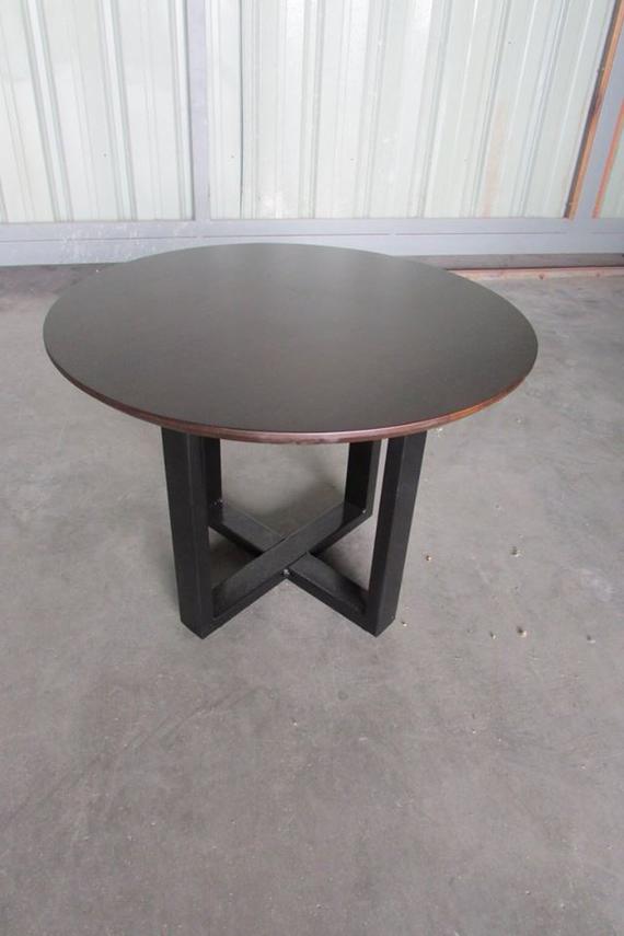 Round dark brown table with black crisscross legs.