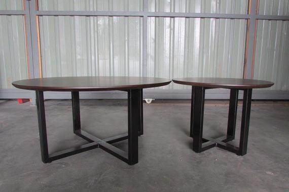 Two round wooden tables with dark legs; one larger, one smaller.