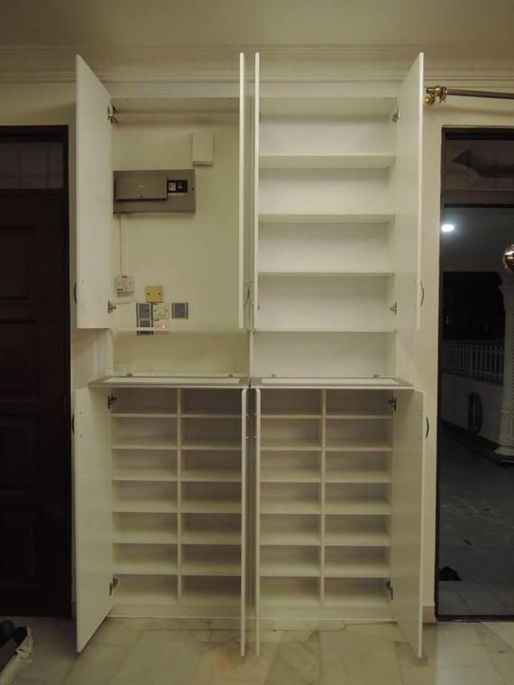 White shoe storage cabinets, open. Shelves are visible, and the upper cabinets are taller than the lower ones.