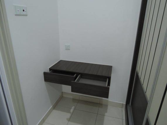 A dark brown floating desk with open drawers against a white wall.