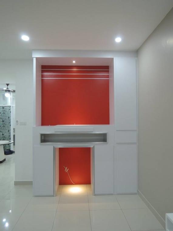 White built-in entertainment unit with red accents. Recessed lighting, rectangular opening with a red interior.