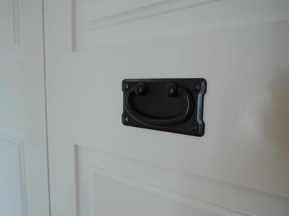 Black handle on a white paneled door.