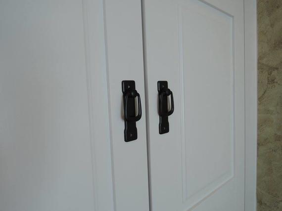 White cabinet doors with black handles.