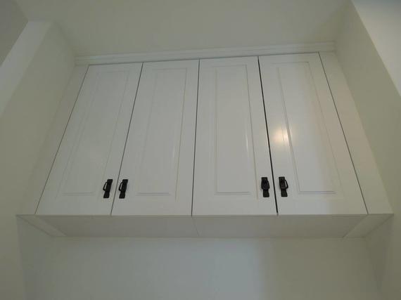 White kitchen cabinets with black handles.