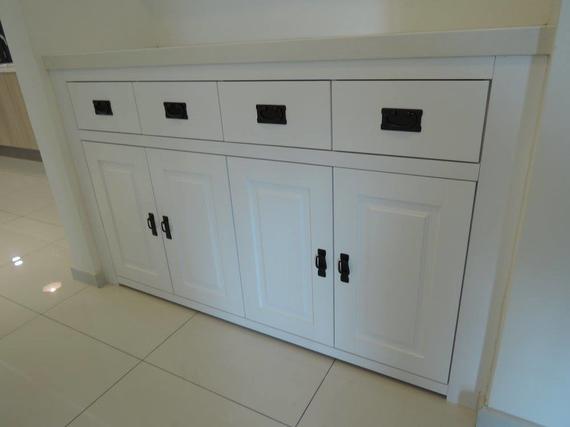 White cabinet with black handles and drawers.