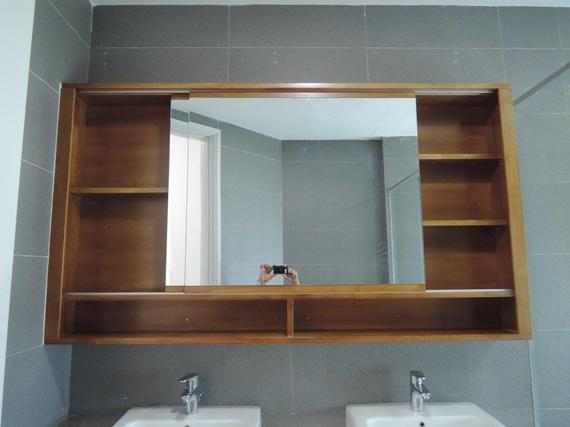 Wooden bathroom mirror with shelves, over two sinks.