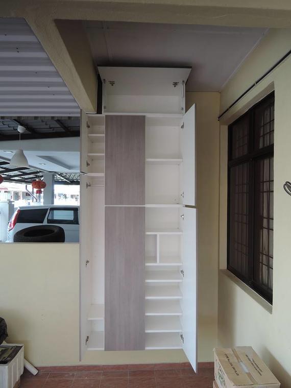Tall, open cabinet with shelves and central gray panel; installed between a beige wall and window.