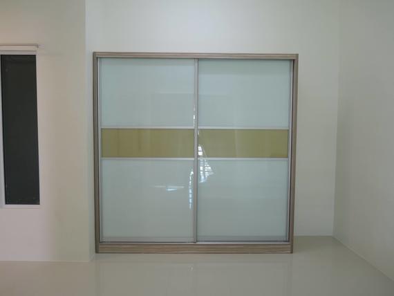 Sliding-door closet with white and yellow panels against a white wall in a room.