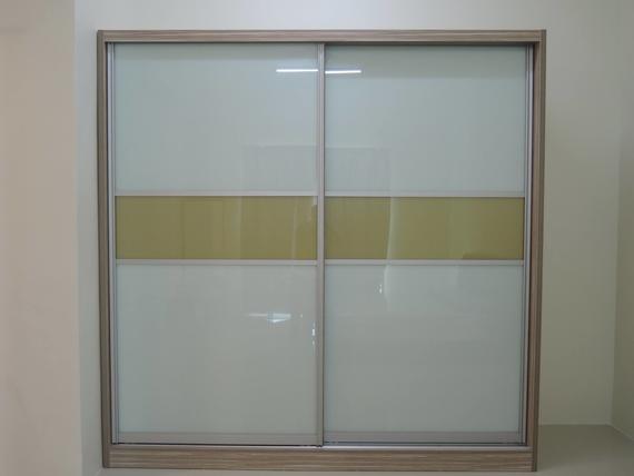 Sliding door wardrobe with frosted glass panels, beige frame, and gold band. Set in a white room.