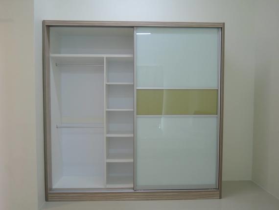Beige and white sliding door closet with shelf and hanging rod; one door has frosted glass with yellow stripe.