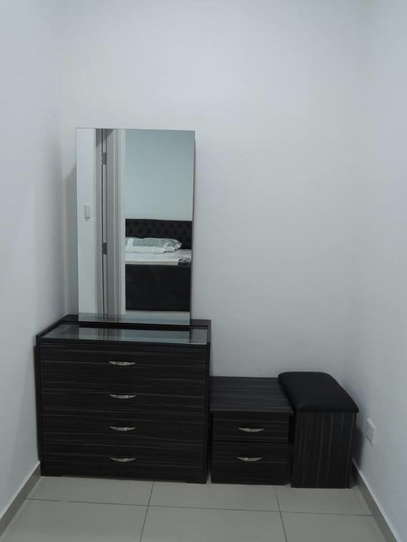 Dark dresser with mirror, small cabinet, and bench against a white wall in a room.