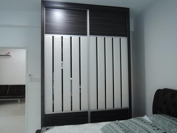 Sliding door wardrobe with brown and white panels in a bedroom.