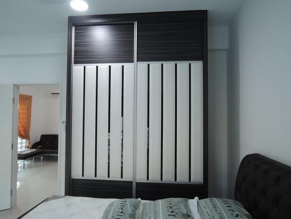 Dark wood sliding closet with vertical white panels in a bedroom.
