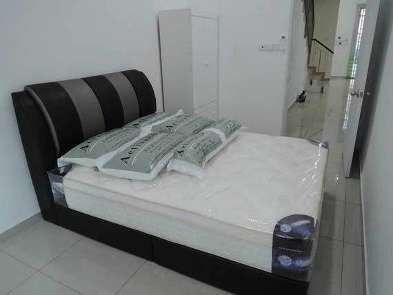 Bed with pillows and headboard in a room with a closet and hallway.