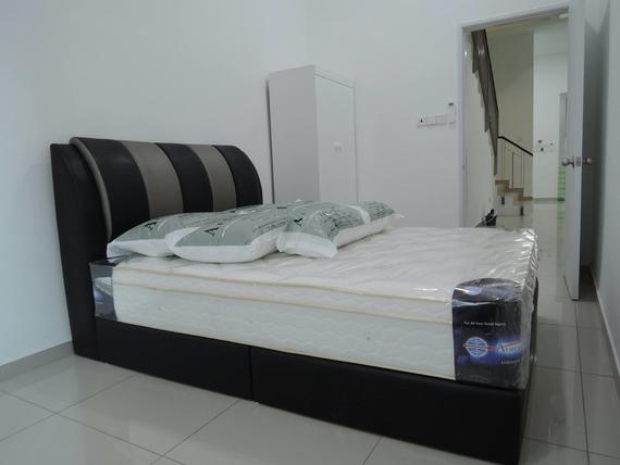 Bedroom with bed, mattress, pillows, and closet. Light-colored walls and floor. Doorway leads to stairs.