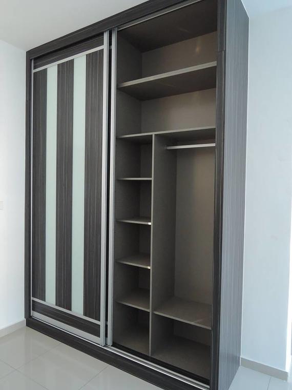 Dark wood sliding door wardrobe with vertical striped panel, open to reveal shelves and hanging rod.