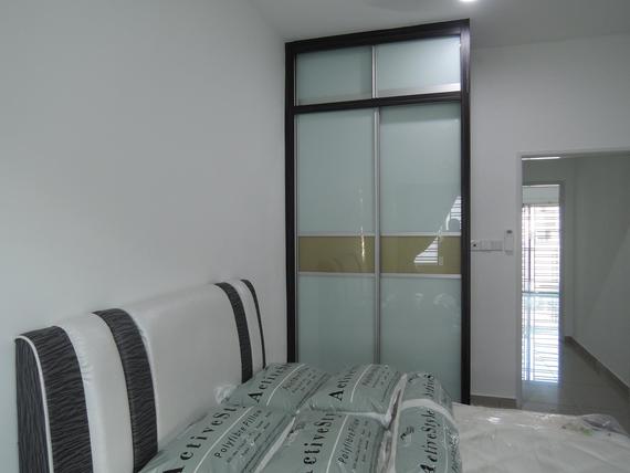 Bedroom with sliding closet doors; white walls, bed with striped headboard, open doorway.
