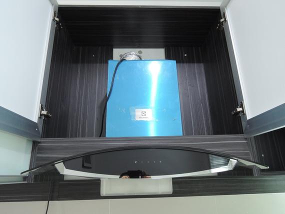 Blue appliance inside a dark cabinet with open doors and a black, curved control panel.