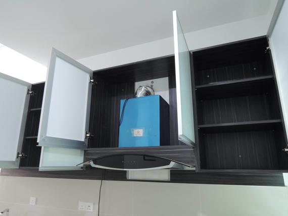 Kitchen cabinets with open doors. Hood vent installed, blue box inside.