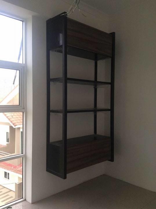 Wall-mounted wooden and metal shelving unit in corner near a window.