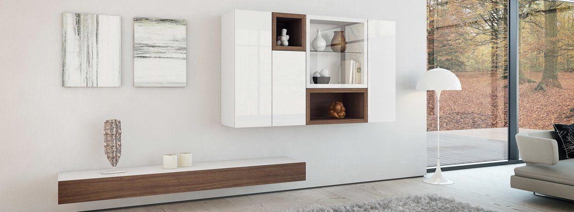 Modern living room with white wall cabinets, wood accents, and artwork. A floor lamp stands near a window.