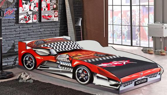 Red race car bed in a boy's bedroom with race car decor on walls and bedding.