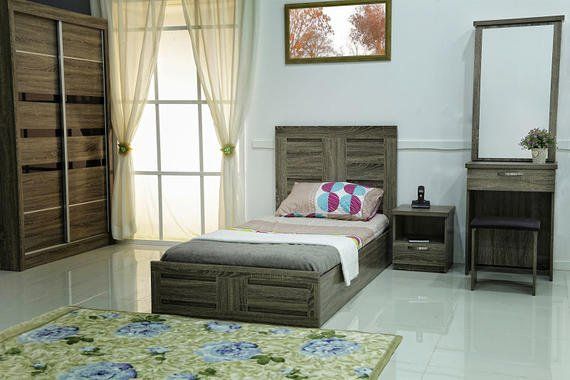 Bedroom with wooden furniture: bed, wardrobe, vanity, bedside table; window with curtains; patterned rug.