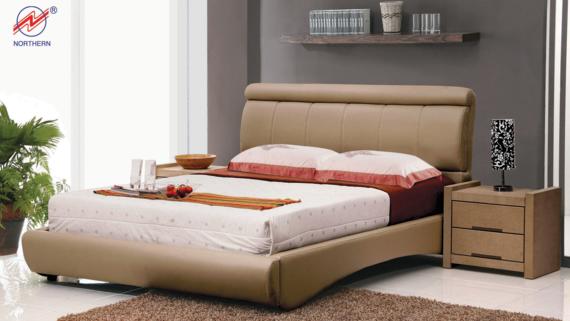 Beige bed with matching nightstand, bedding, and decorations in a modern bedroom.