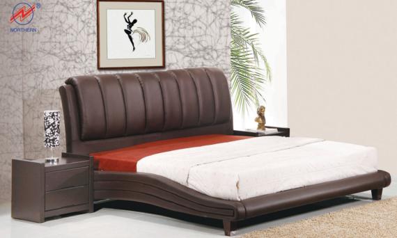Dark brown leather bed with nightstand and artwork in a bedroom.