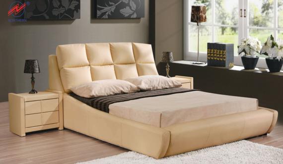 Beige leather bed with oversized, square-stitched headboard and attached nightstands in a bedroom setting.