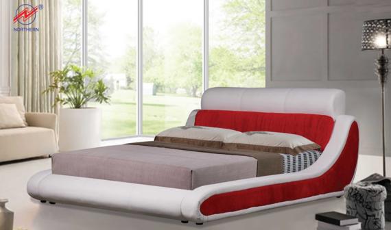 Modern bed frame with white and red accents, cushions, and headboard, set against a bright window.