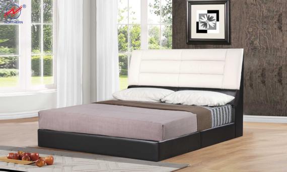 Bed with black base and white, cushioned headboard.