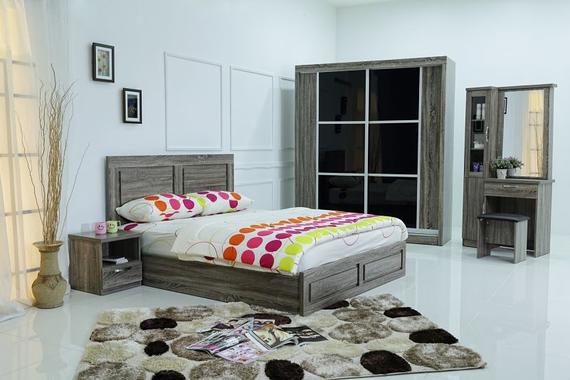Bedroom set with a bed, wardrobe, vanity, and rug. Light wood tones, colorful bedding.