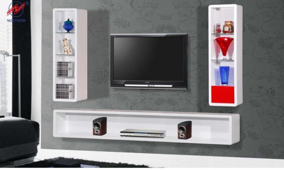 White wall-mounted entertainment center with a TV, shelving, and decorative items against a gray wall.