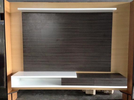 Modern TV wall unit with dark brown and white shelving.