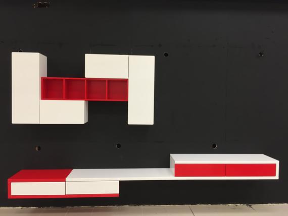 White and red modular wall shelves against a dark wall.