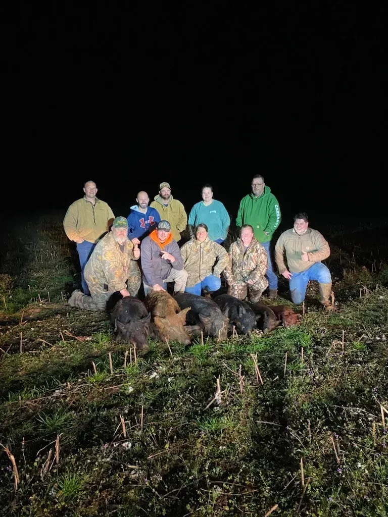 A group of men are posing for a picture in a field at night.
