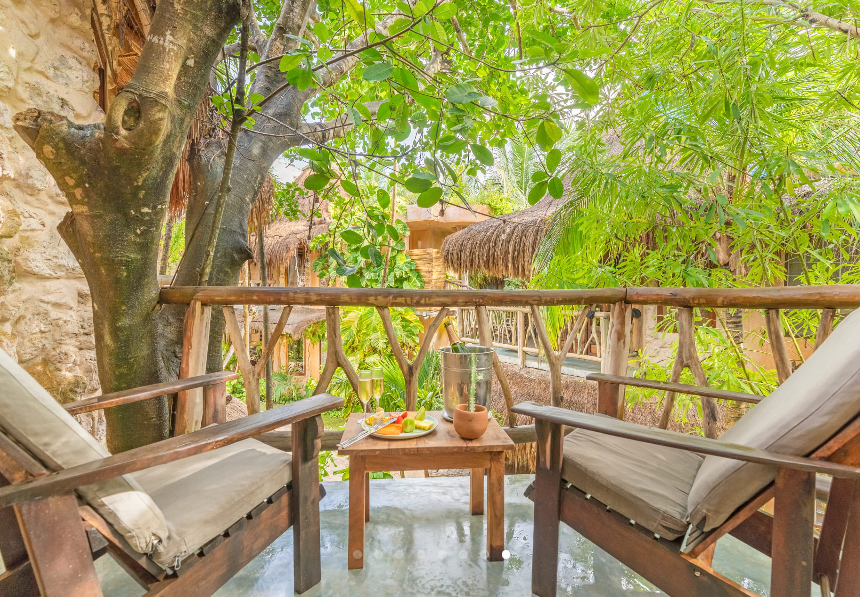A woman sits on a bench overlooking a valley at sunset
