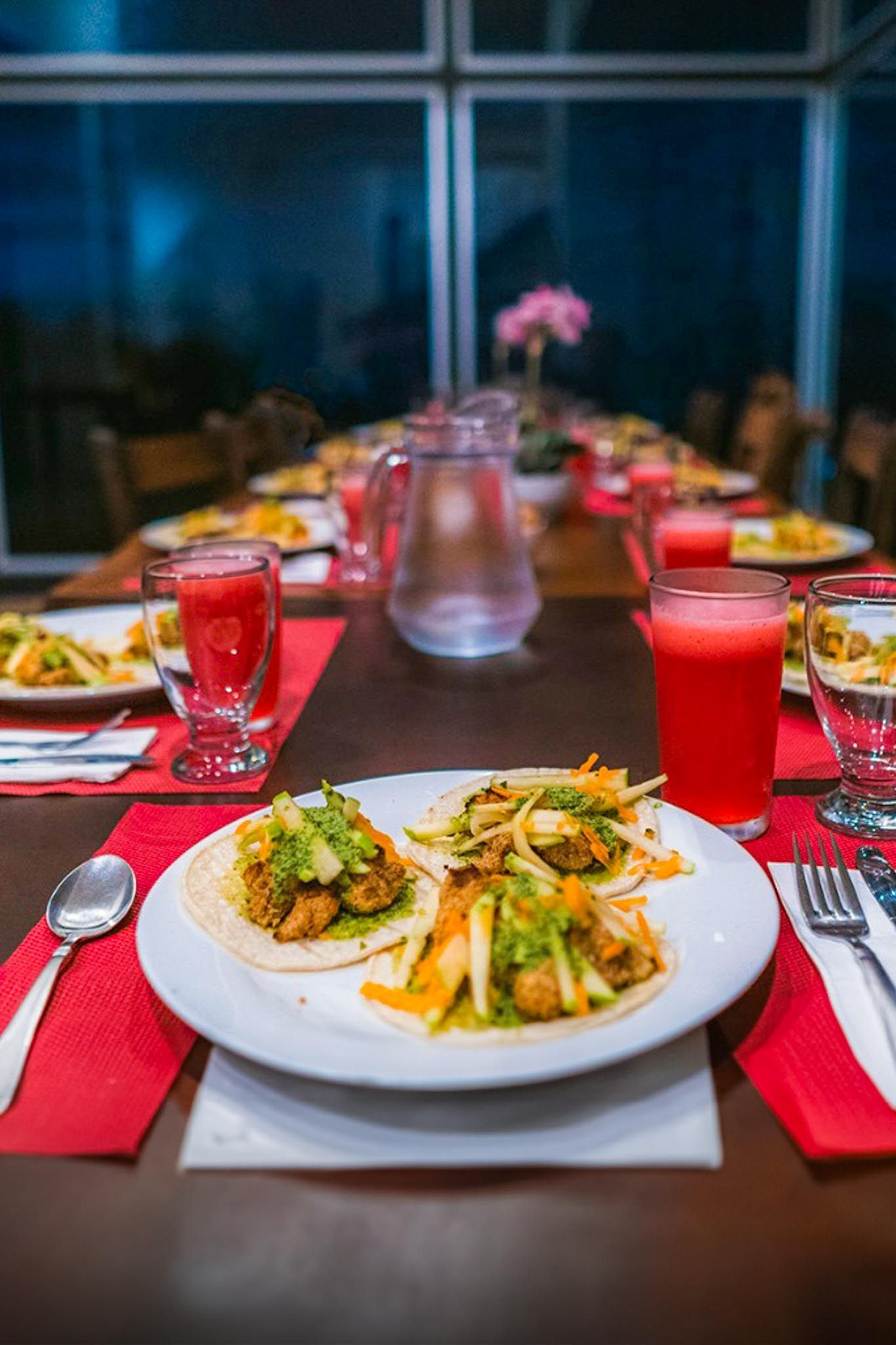 A long table with plates of food and drinks on it.