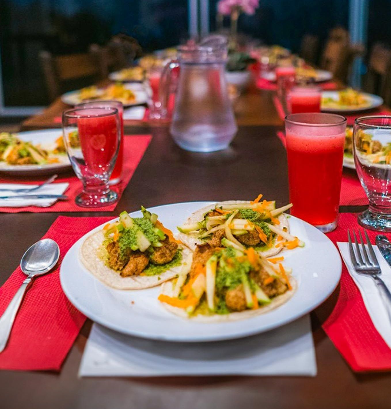 A long table with plates of food and drinks on it.