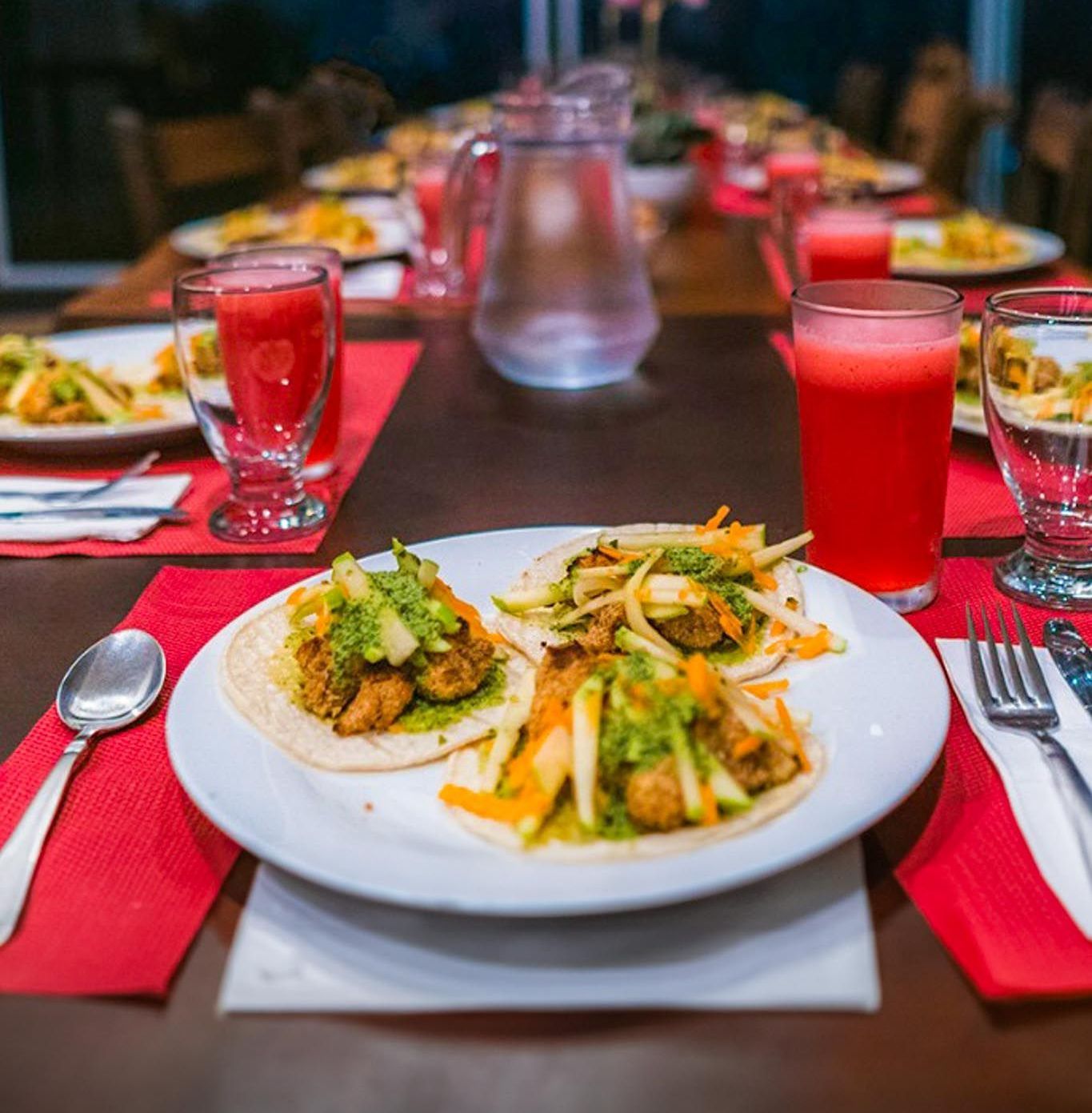 A long table with plates of food and drinks on it.