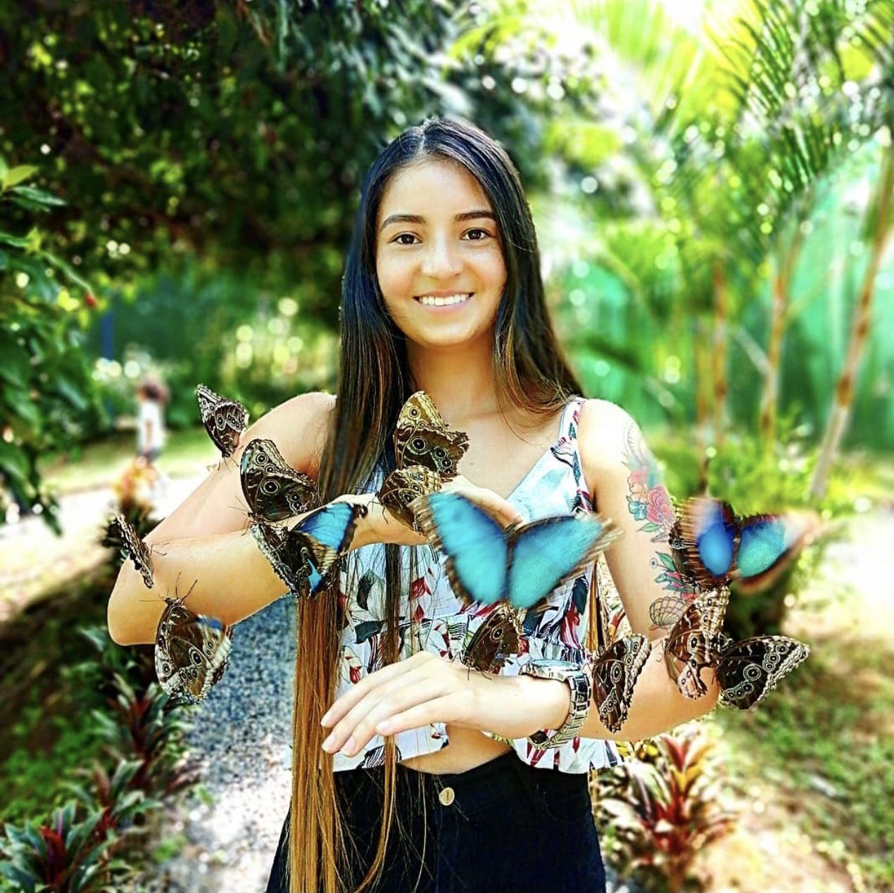A woman is holding a bunch of butterflies in her hands.