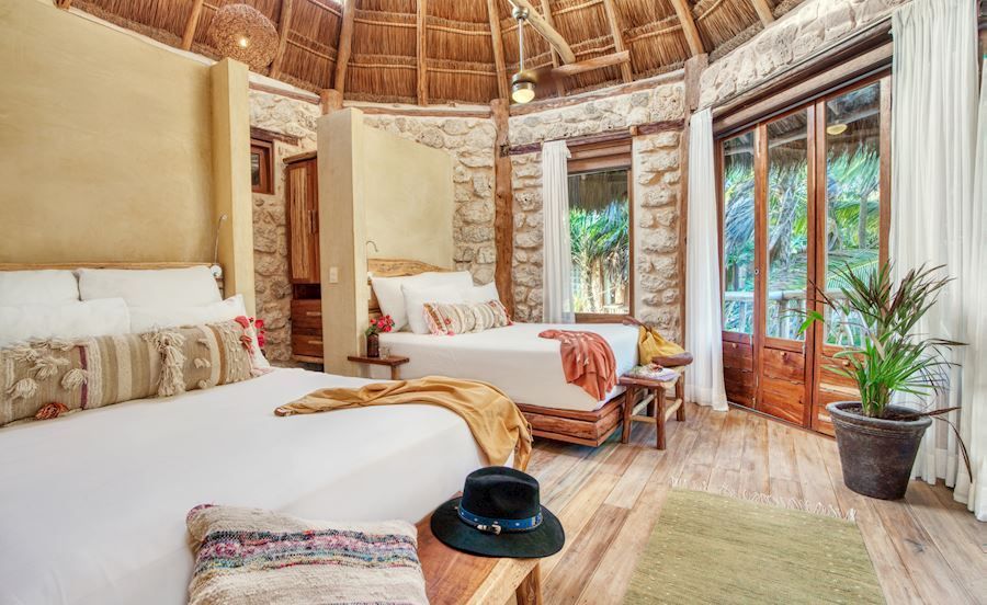 A man is walking up a set of wooden stairs in the jungle.