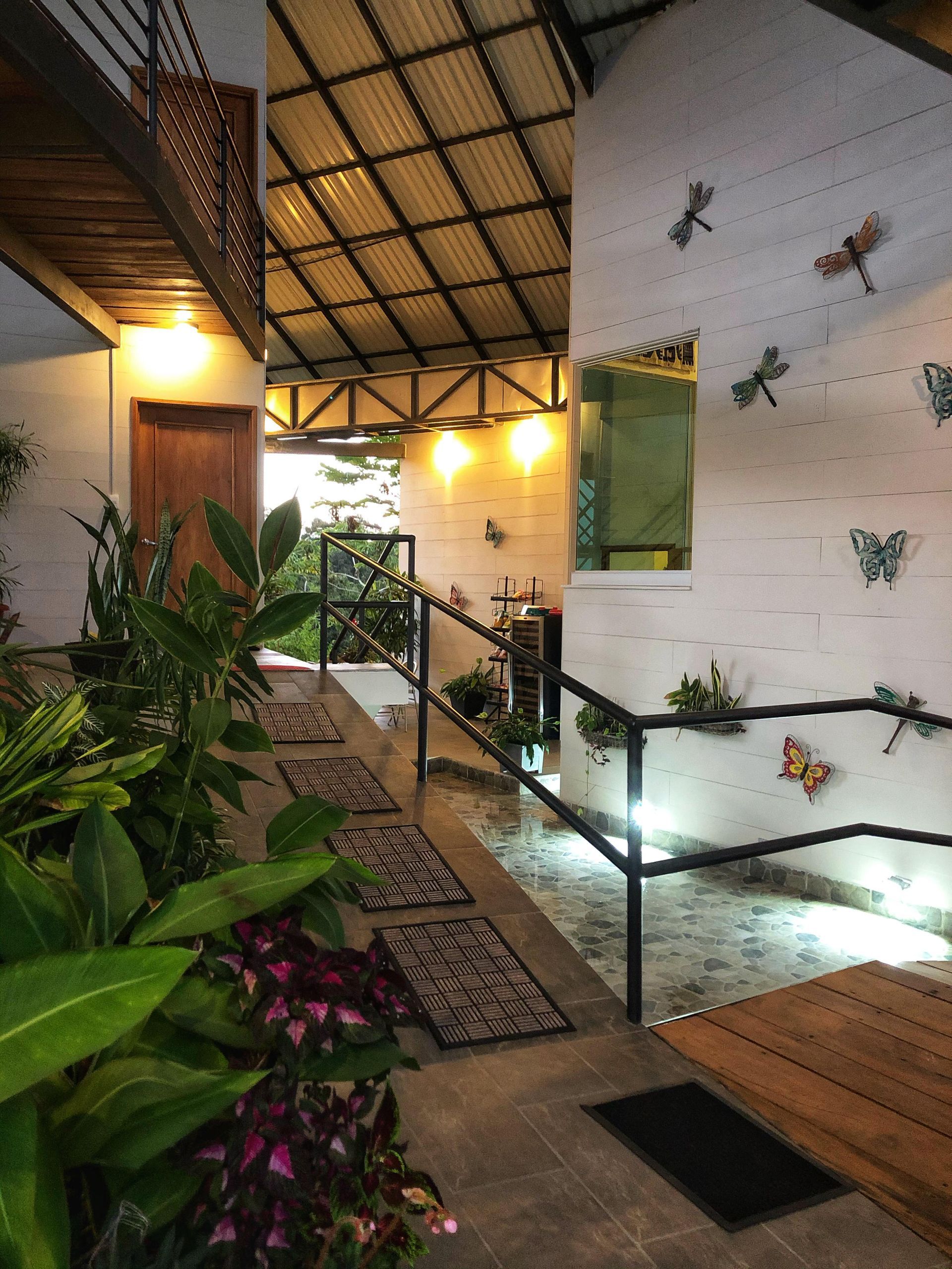 A hallway with plants and butterflies on the wall