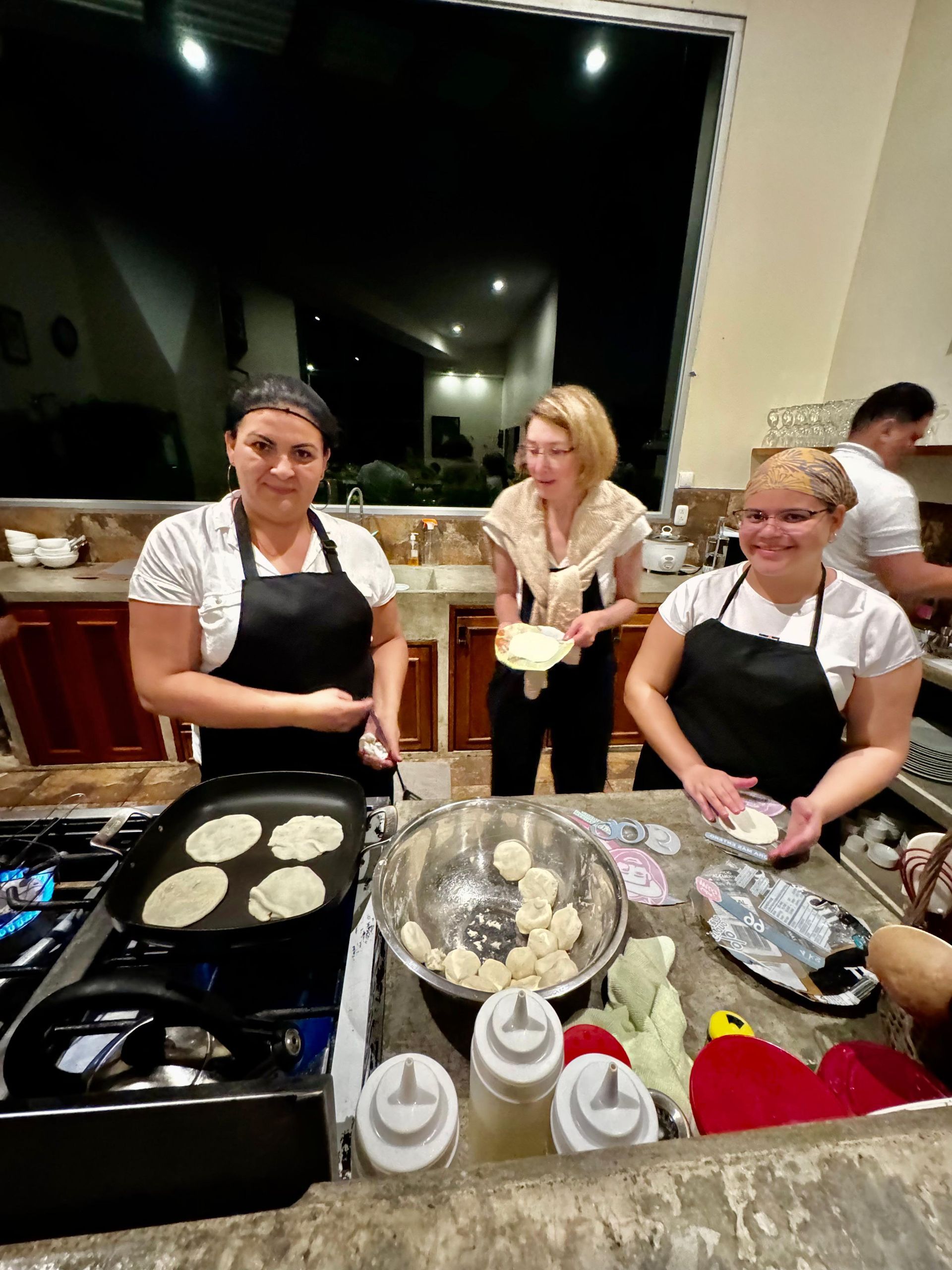 A group of women are preparing food in a kitchen.