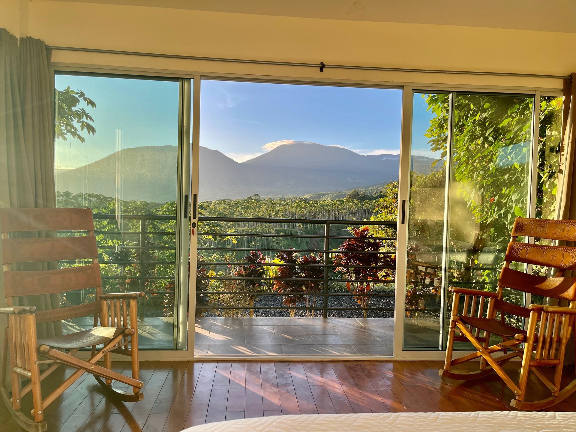 A room with two rocking chairs and a sliding glass door