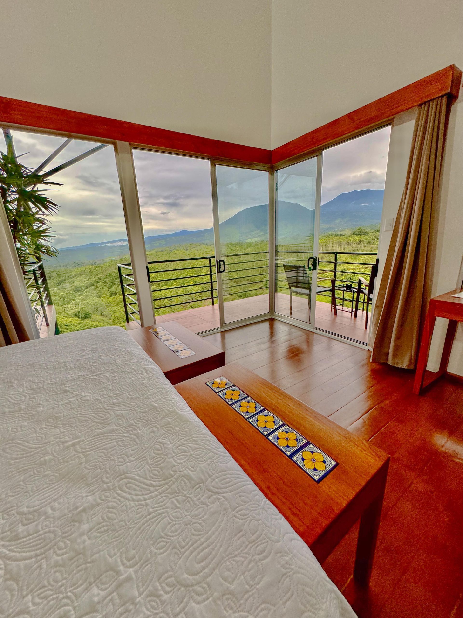 A bedroom with a large window and a view of mountains