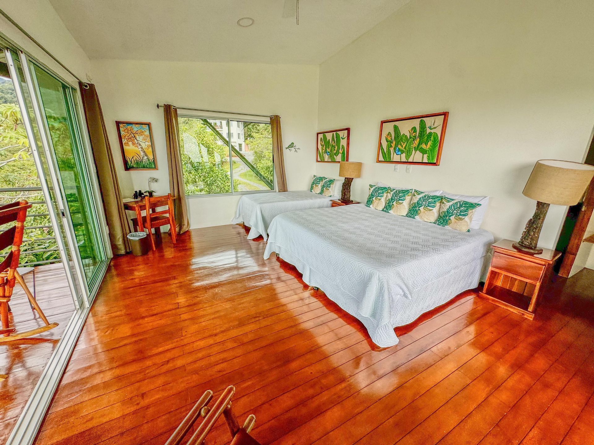 A bedroom with two beds and a sliding glass door.
