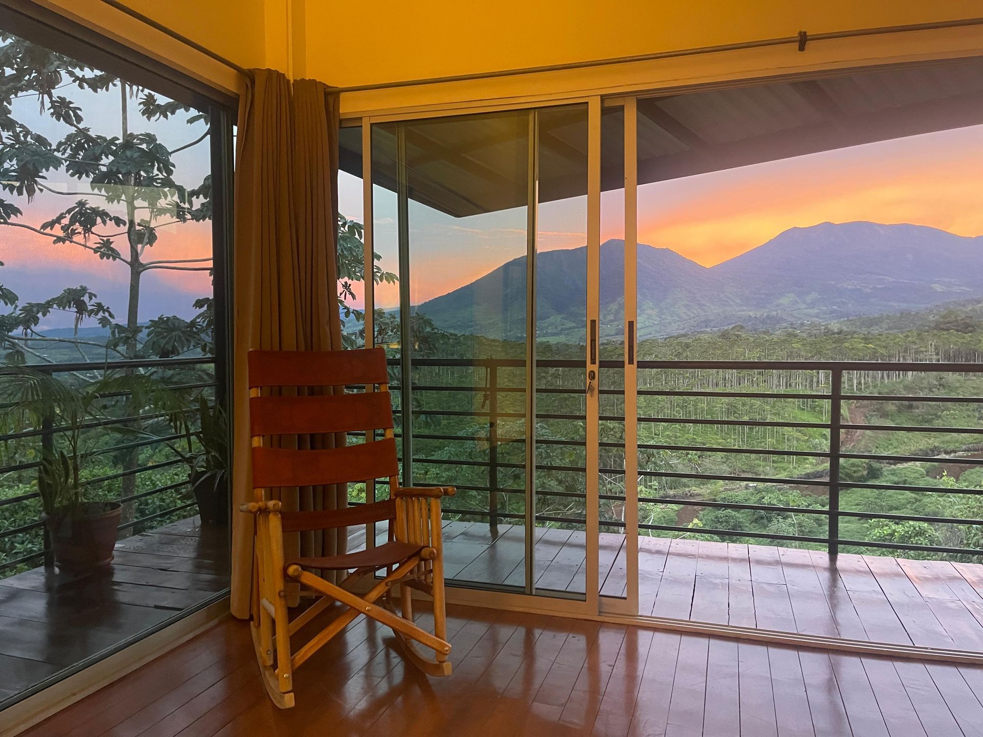 A rocking chair in a room with a view of mountains